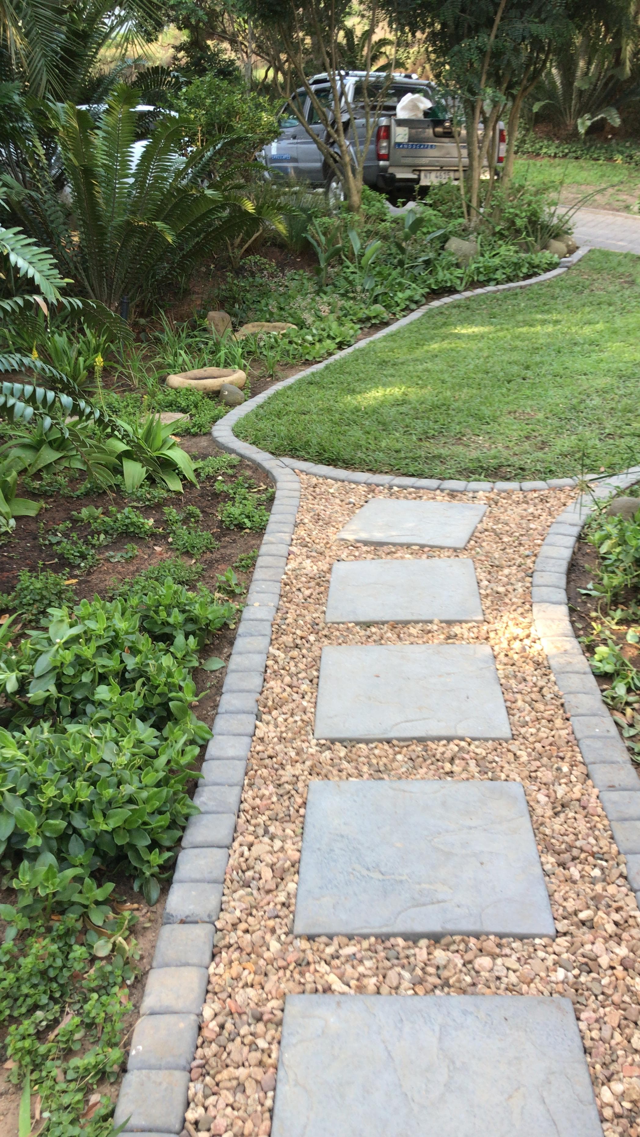 Winding cobblestone-edged stepping stone path through garden