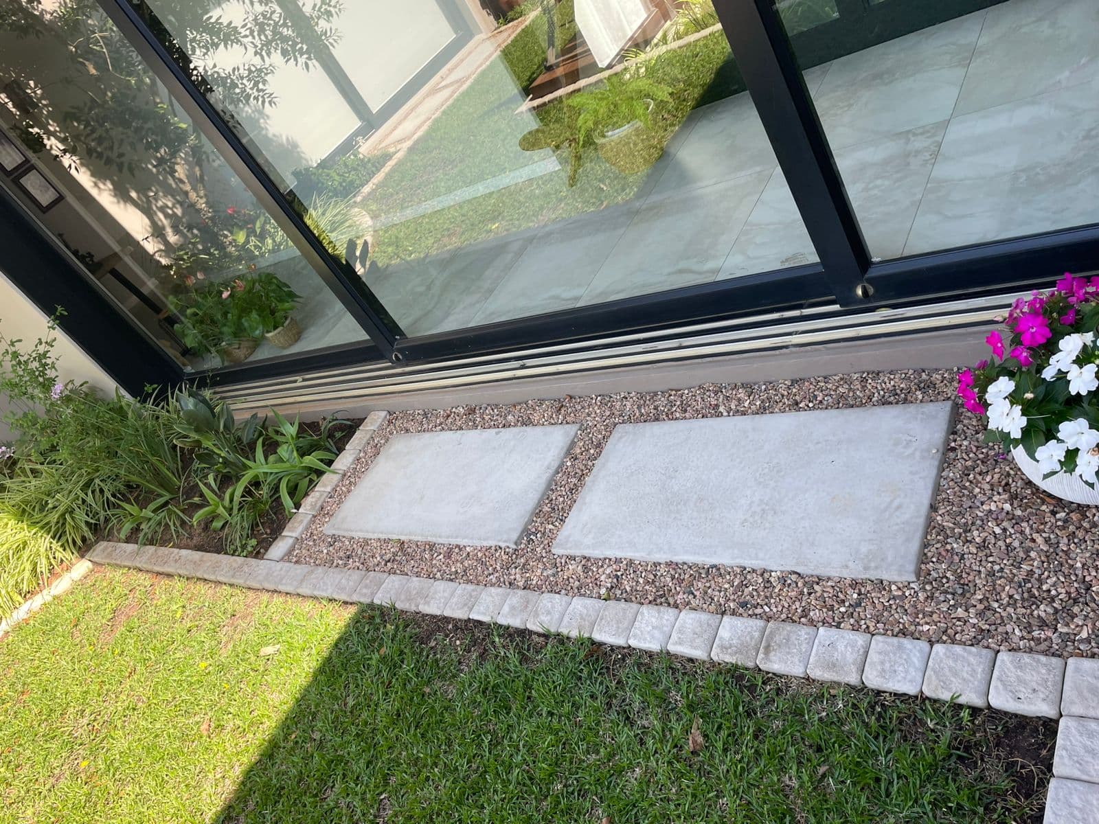 Stepping stones with gravel border and container flowers