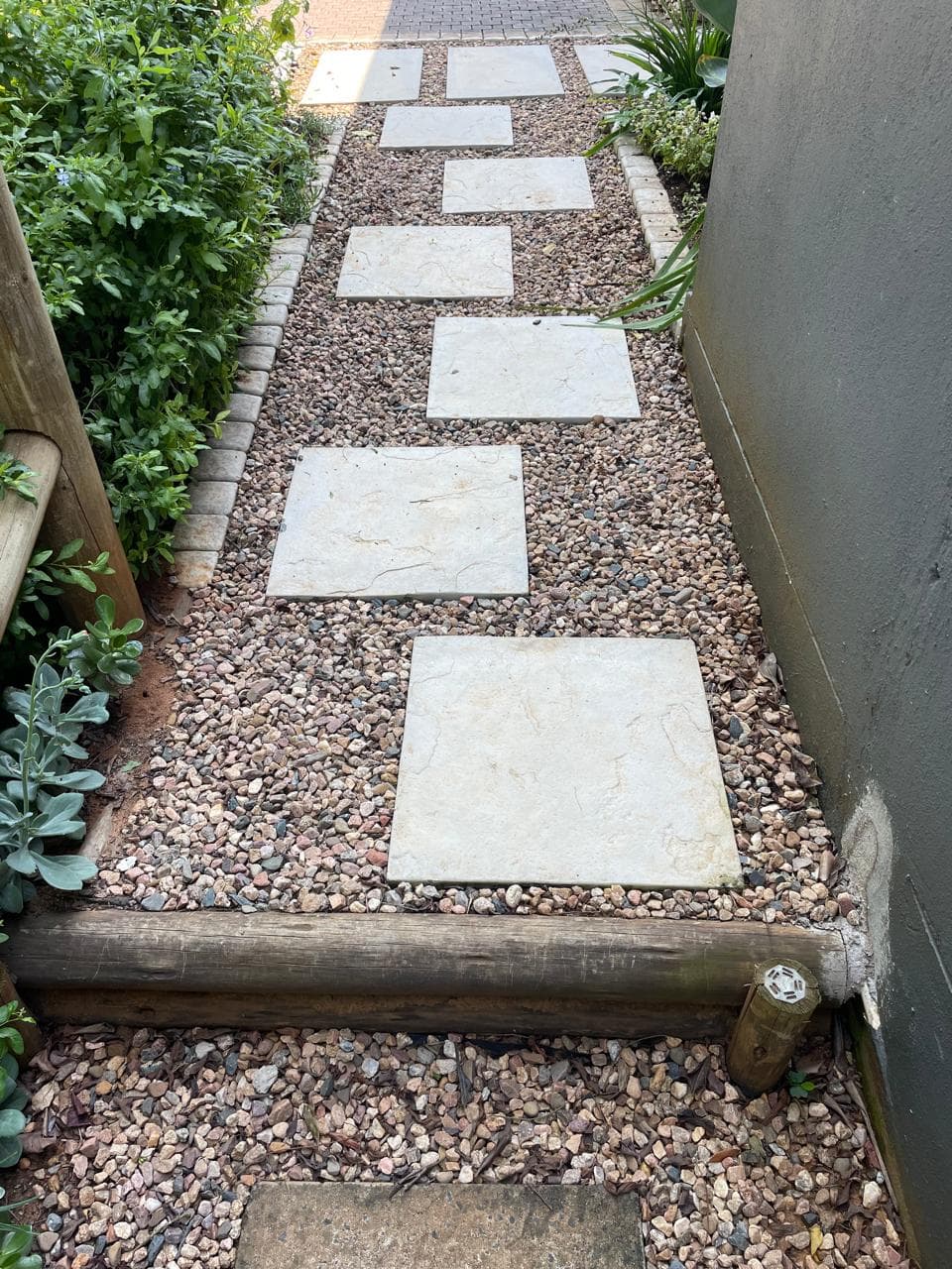 Neat stepping stone pathway on gravel along side passage